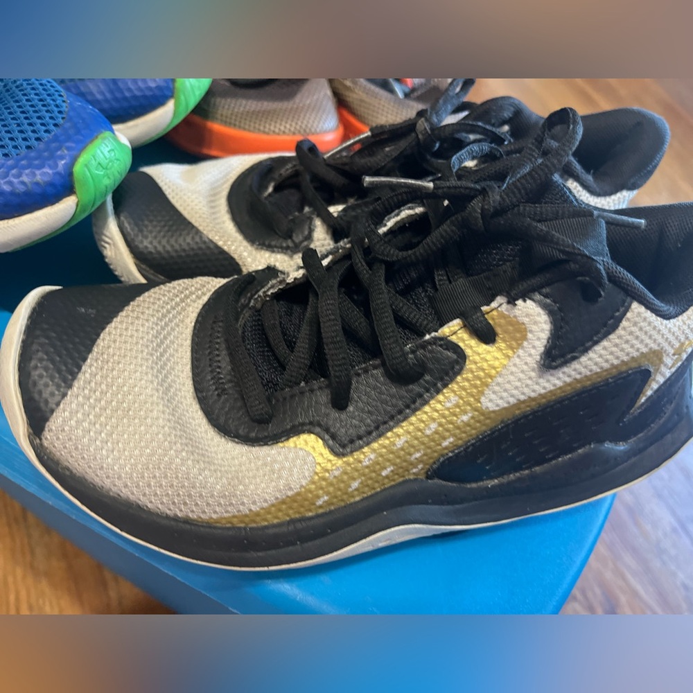 Under Armour Kids Black, Gold, and White Sneakers